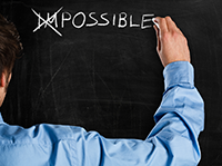 The word impossible written on a chalkboard with the first two letters crossed out